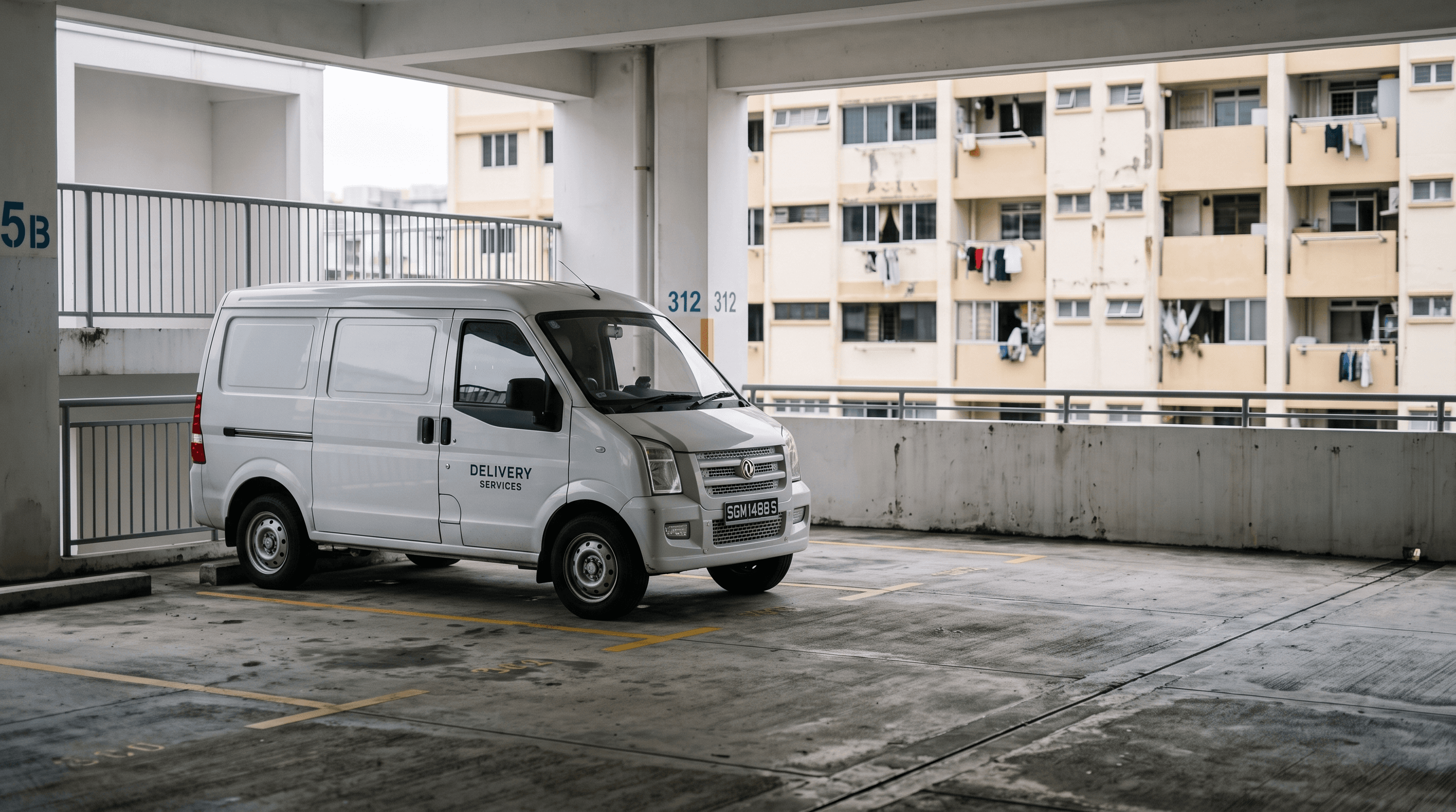 A white compact high-roof cargo van parked in an empty Singapore HDB multi-storey car park deck, a weathered HDB residential block visible behind under soft overcast light